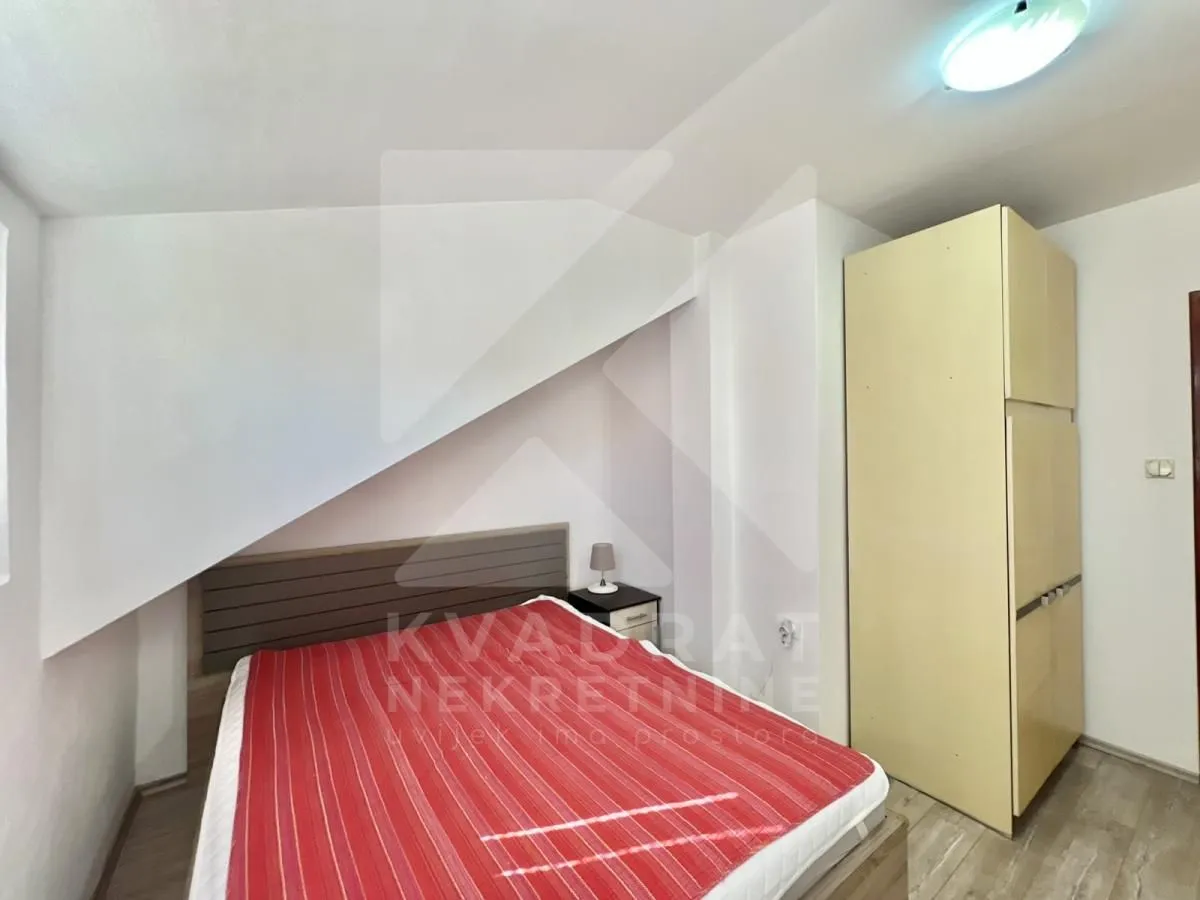 Furnished bedroom with a double bed and a wardrobe in the attic.