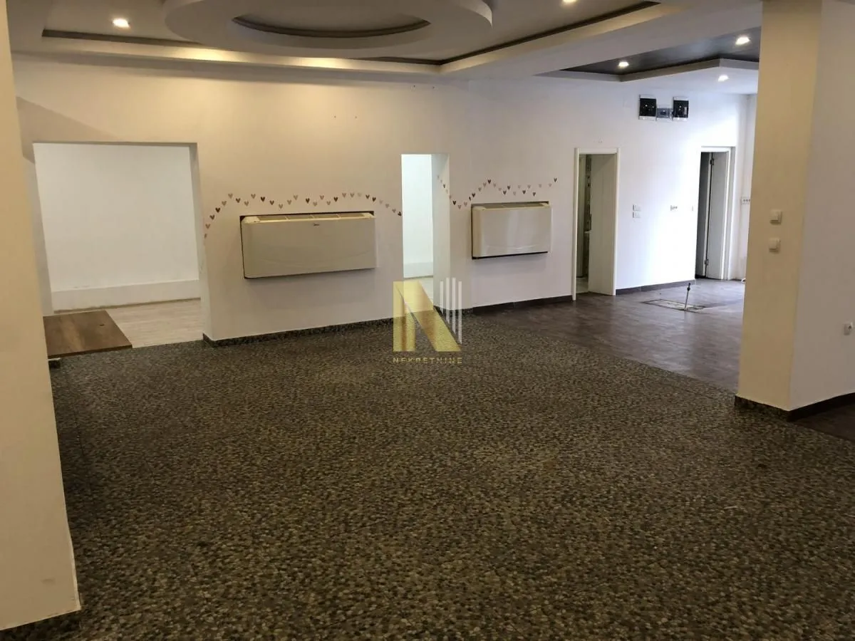 Spacious empty room with white walls and a drop ceiling.
