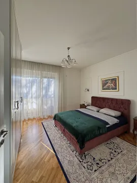 Uređena spavaća soba sa bračnim krevetom, velikim garderoberom i drvenim podom. - image 3