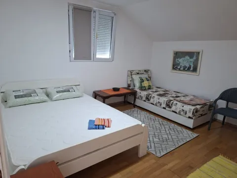 Attic bedroom with two beds and white walls. - image 6