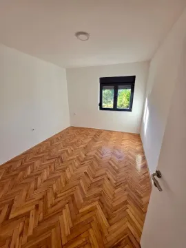 Empty room with parquet flooring and a window. - image 9