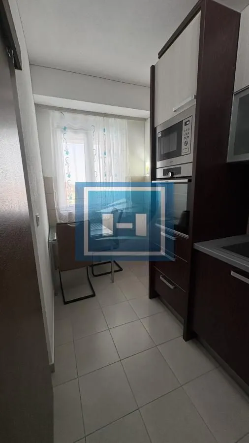 Smaller kitchen with built-in units and a dining table by the window.