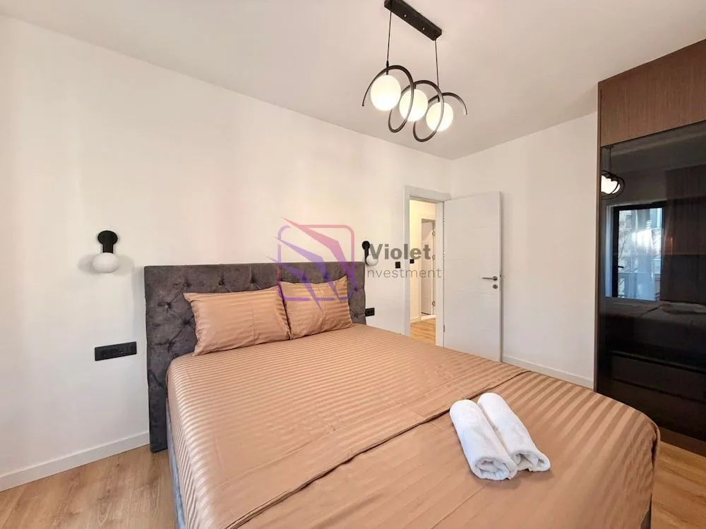 Furnished bedroom with a double bed, wardrobe, and modern lighting.