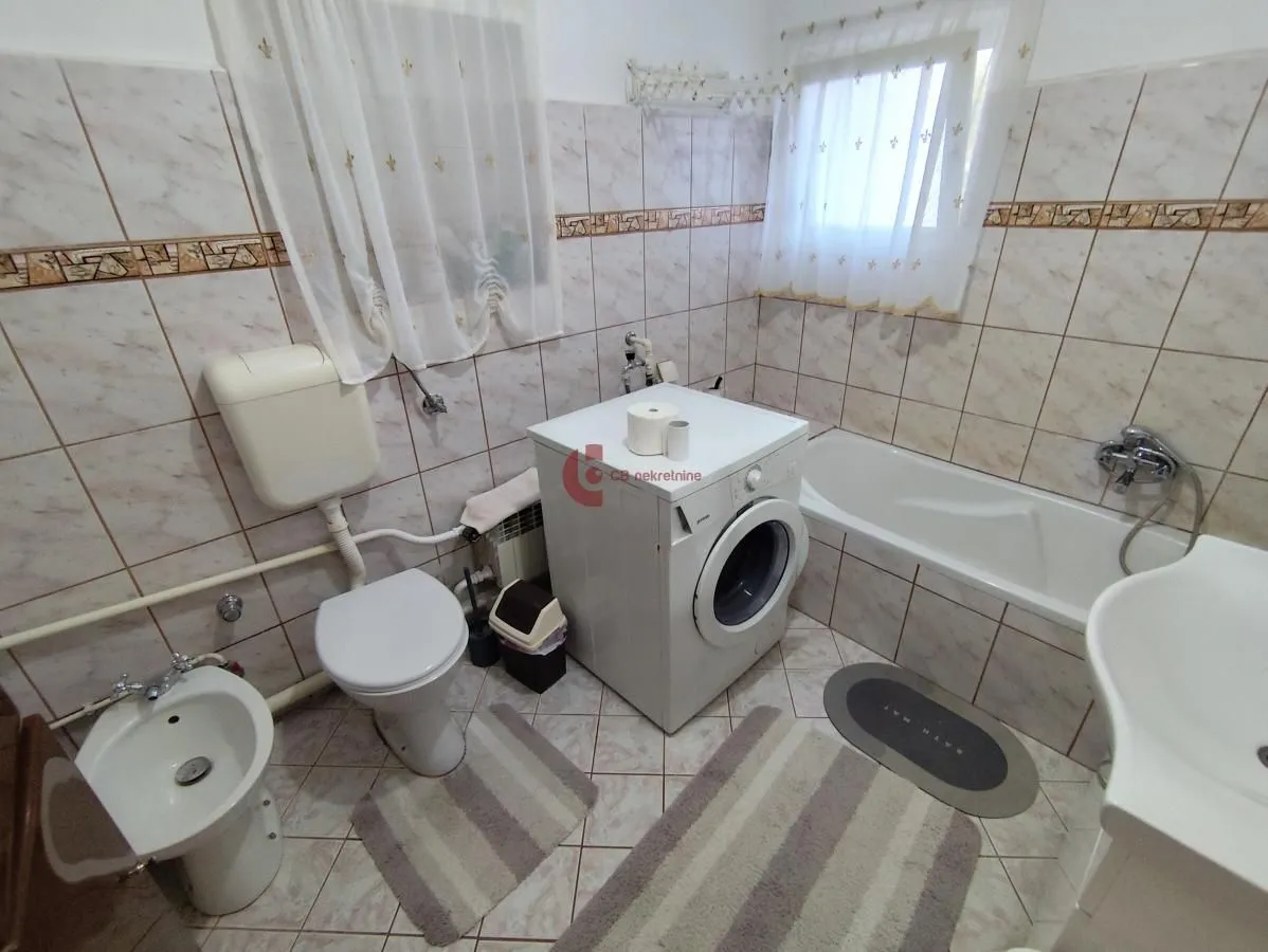 Bathroom equipped with sanitary ware, bathtub, and washing machine.