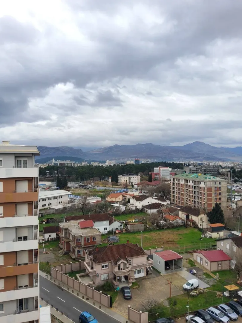 Elevated view of a city neighborhood and distant mountains.