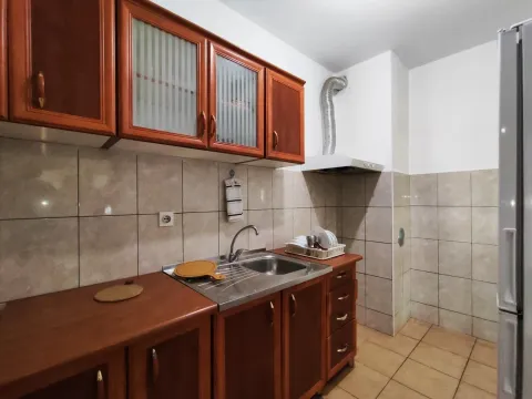 Jednostavna kuhinja sa drvenim elementima, sudoperom i pločicama. - image 11