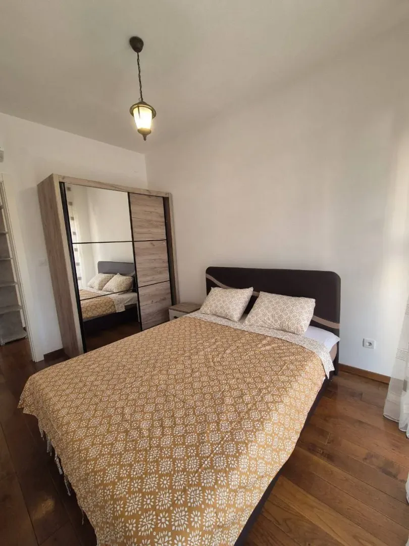 Furnished bedroom with a double bed and a wardrobe.