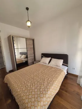 Furnished bedroom with a double bed and a wardrobe. - image 6
