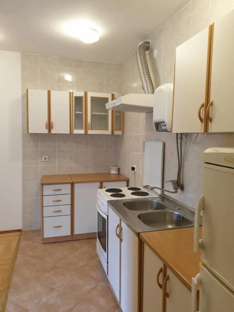 A simple kitchen with white cabinets and wooden details.