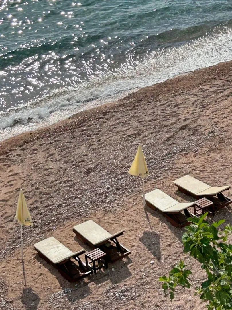 Pogled na plažu sa ležaljkama i suncobranima.