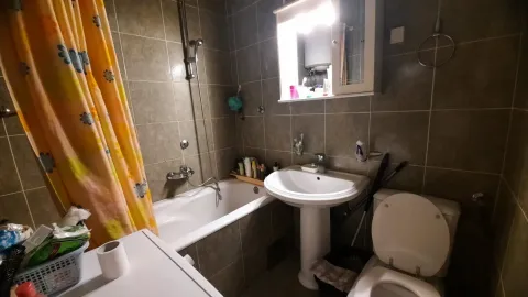 Bathroom with a bathtub, sink, and toilet. - image 15