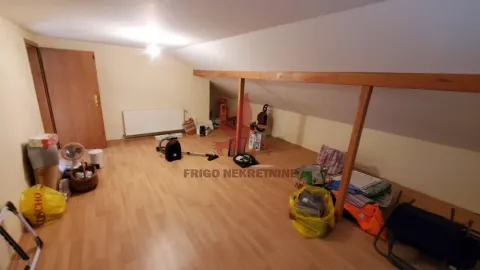 Nenameštena potkrovna prostorija sa drvenim podom i kosim plafonom. - image 16