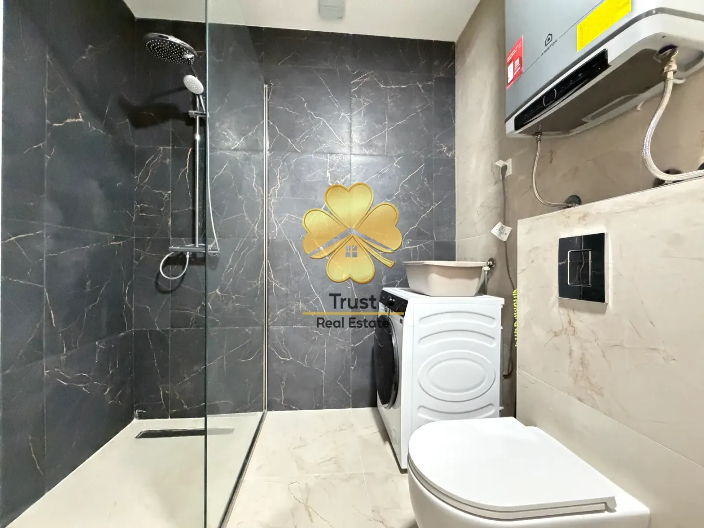 Moderne kupatilo sa tuš kabinom, veš mašinom i WC šoljom.