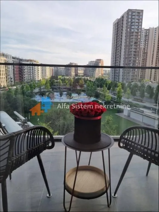 Furnished balcony with a table, chairs, and a view of the city neighborhood.