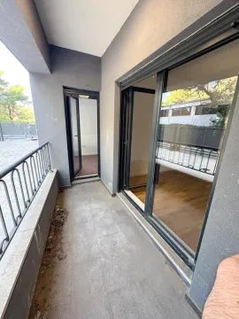 Nenamješten balkon sa staklenim kliznim vratima i metalnom ogradom. - image 8