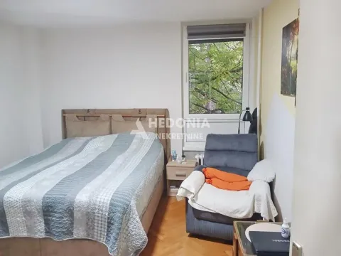 Nameštena spavaća soba sa bračnim krevetom i foteljom pored prozora. - image 5