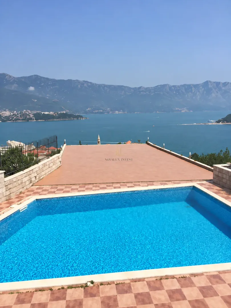 Swimming pool with a terrace and sea and mountain views.