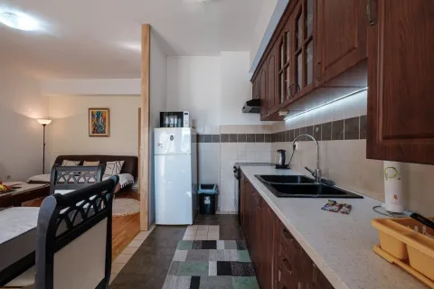 Kuhinja sa drvenim elementima i pogledom na dnevnu sobu. - image 6