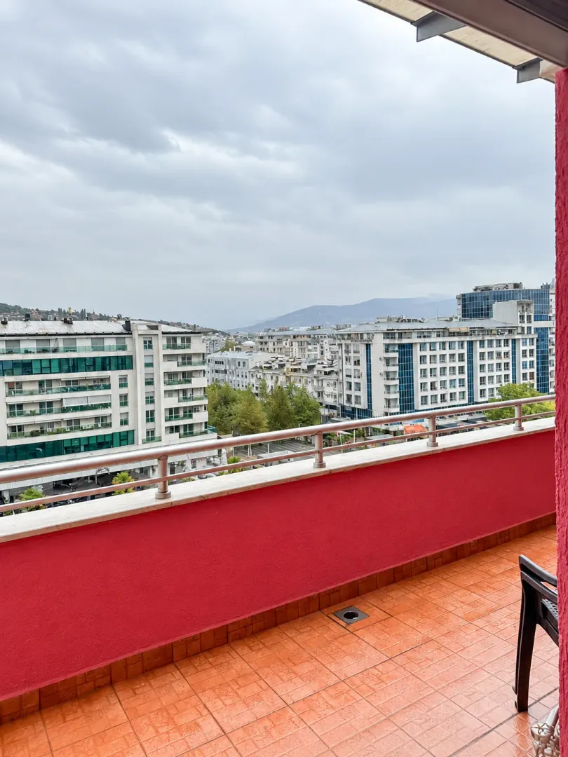 Pogled sa popločane terase na okolne zgrade i gradski pejzaž.