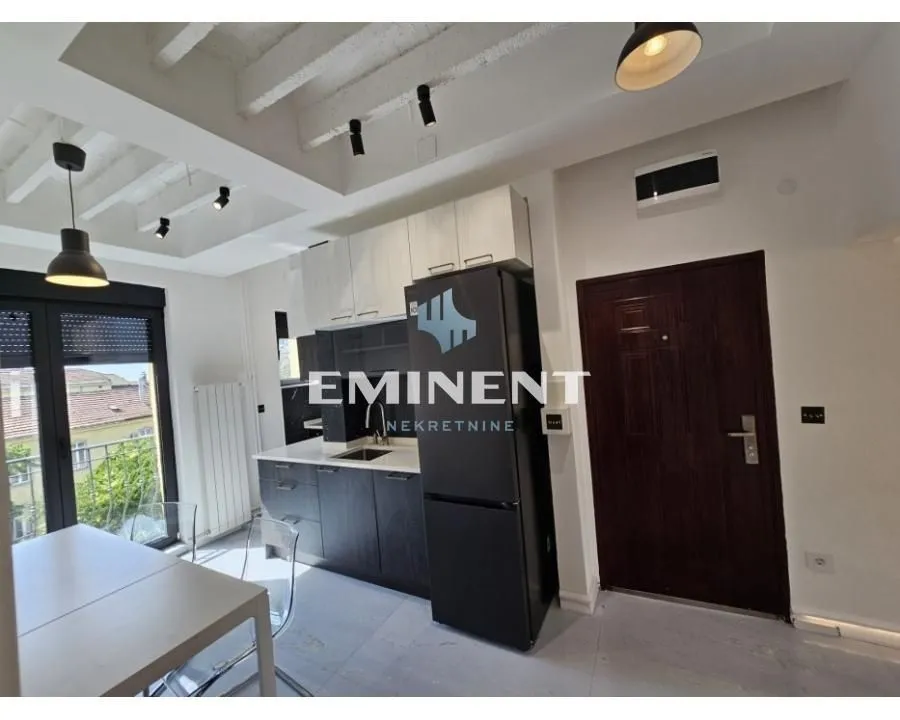 Modern kitchen with fitted units and a dining table by the window.