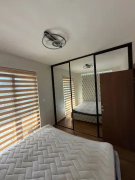 Bedroom with a bed and a large wardrobe mirror. - image 4
