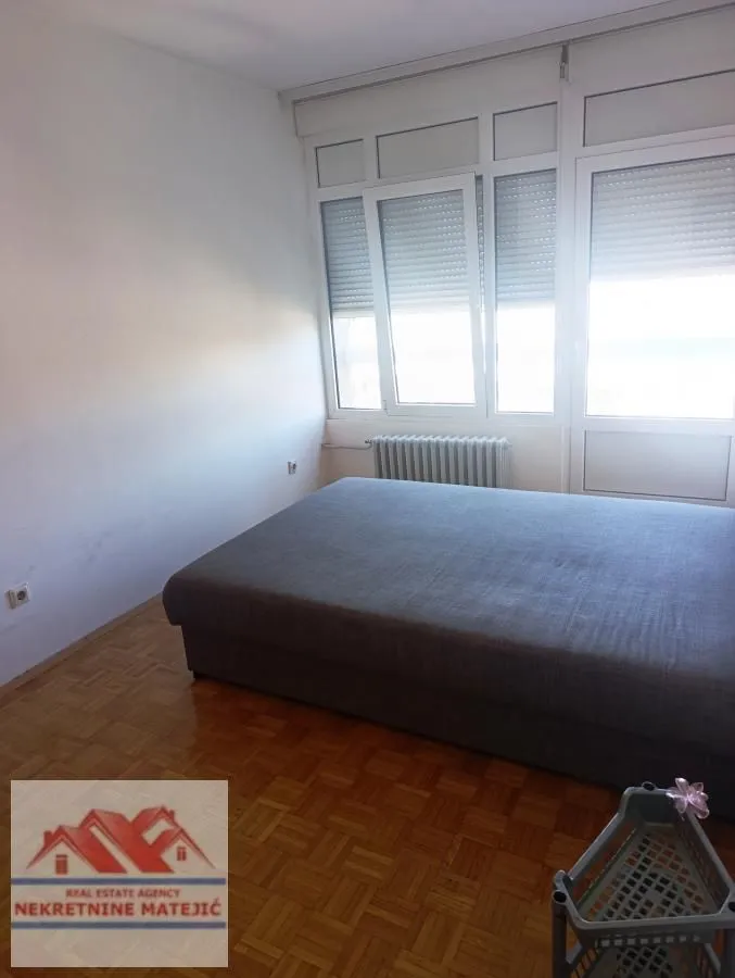 Bedroom with a double bed and parquet flooring.