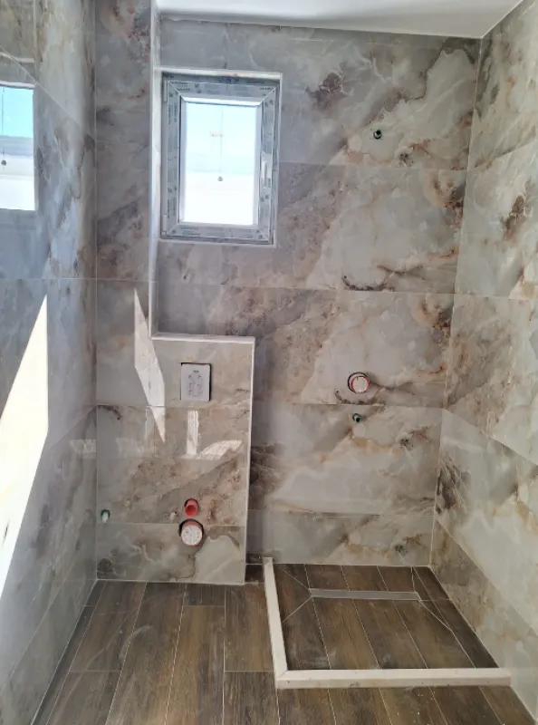 Bathroom in the final stage of renovation with tiles and installations installed.