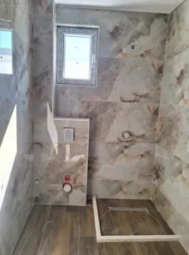 Bathroom in the final stage of renovation with tiles and installations installed. - image 10
