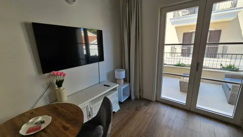 Dnevni boravak sa televizorom, trpezarijskim stolom i izlazom na terasu. - image 4