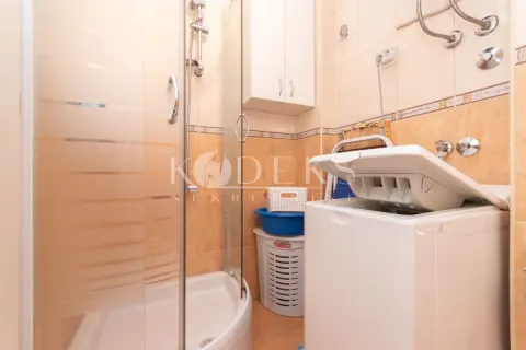 Bathroom with a shower cabin and a washing machine. - image 6