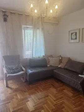 Living room with a sofa, armchair, and wooden parquet flooring. - image 7