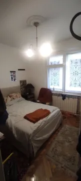 Spavaća soba sa bračnim krevetom, lusterom i prozorima sa vitražom. - image 13