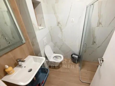 Modernly equipped bathroom with a washbasin, toilet, and shower cabin. - image 2
