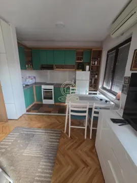 Manja kuhinja sa trpezarijskim stolom i zelenim kuhinjskim elementima. - image 2