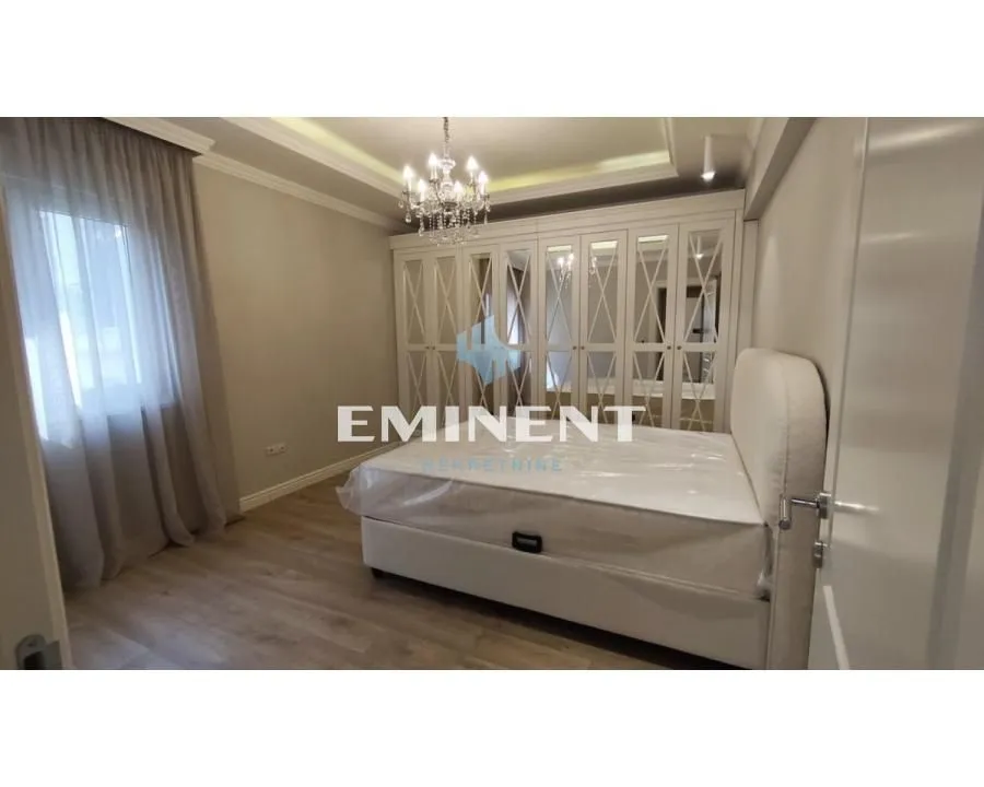 Furnished bedroom with a double bed and a large fitted wardrobe.