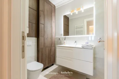 Moderne kupatilo sa bijelim umivaonikom, ugradnim toaletom i visokim drvenim ormarićem. - image 16