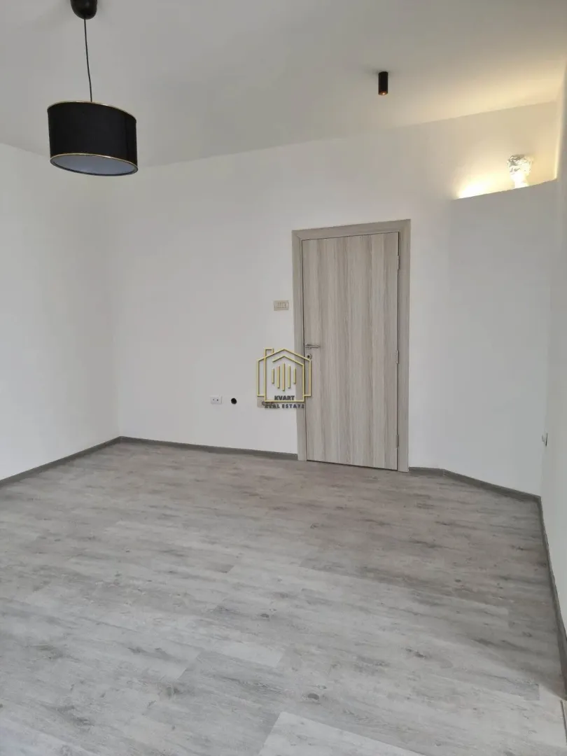 Empty room with laminate flooring and wooden door.