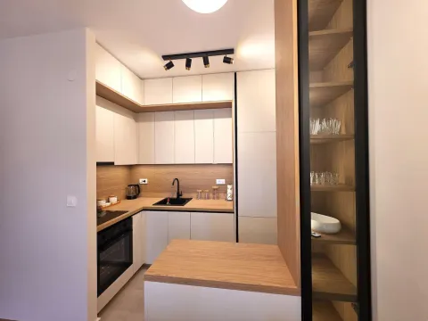 Moderna kuhinja sa bijelim elementima i drvenim detaljima. - image 4