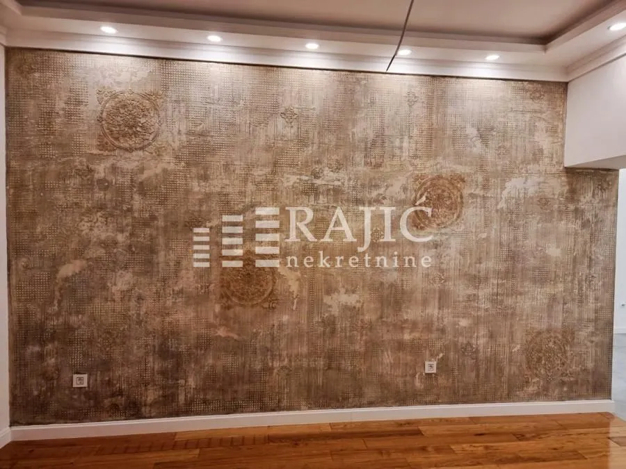 Interior space with a decorative wall and hardwood flooring.