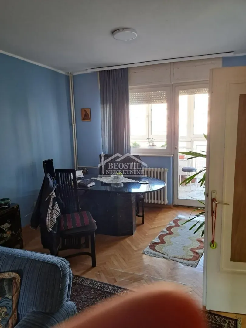 Dnevni boravak sa trpezarijskim stolom i izlazom na terasu.