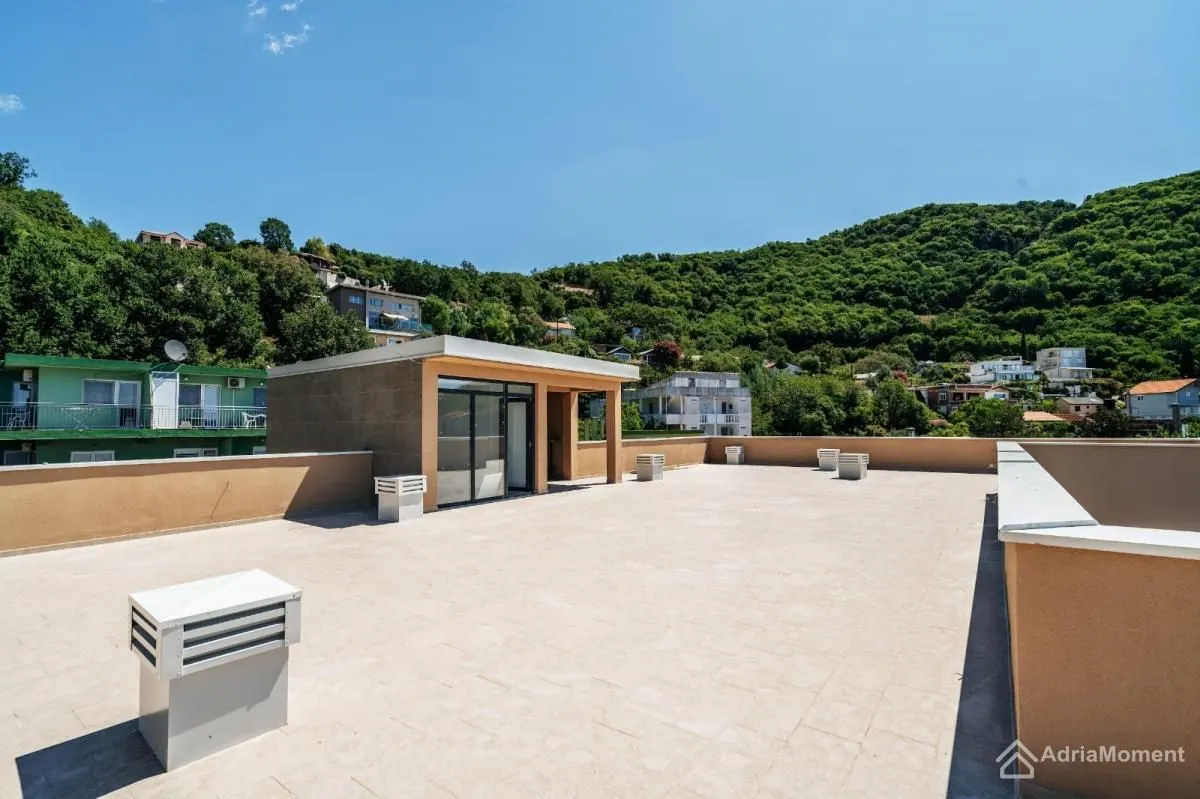 Large spacious rooftop terrace overlooking the surrounding greenery and hills.