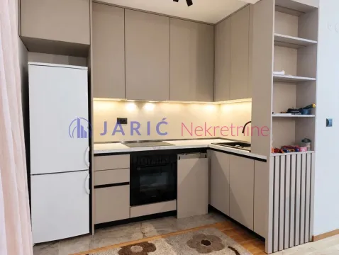 Modern kitchen with beige cabinets and built-in appliances. - image 11