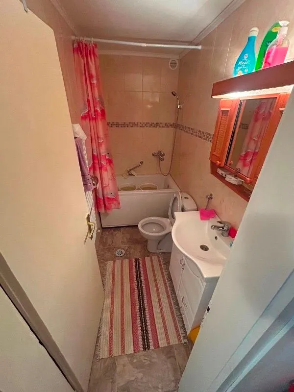 Smaller bathroom with a bathtub, washbasin, and toilet.