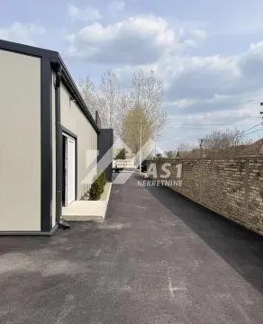 Asphalted yard and driveway next to the building with a fence. - image 4