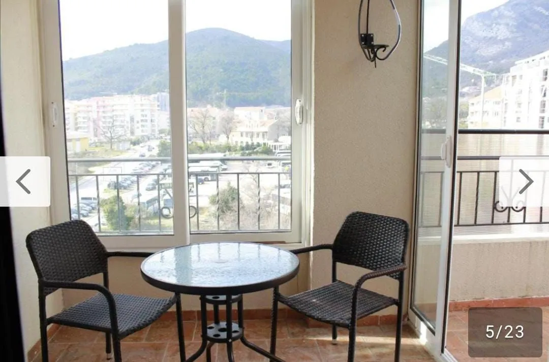 Covered terrace with a small table, chairs, and a view of the surroundings.