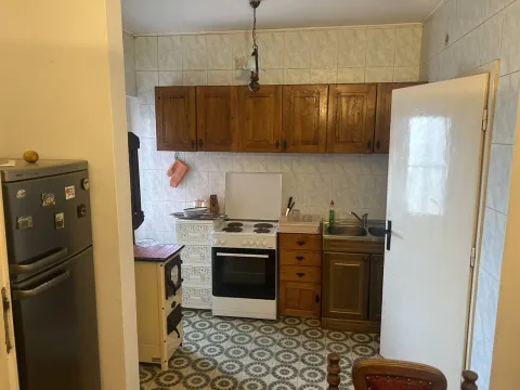 Classic kitchen with wooden cabinets, appliances, and patterned floor tiles. - image 14
