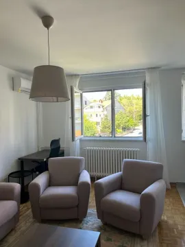 Dnevna soba sa foteljama, stočićem i radnim stolom pored prozora. - image 3