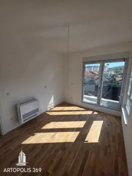 Empty room with wooden flooring, air conditioning unit, and balcony doors. - image 14