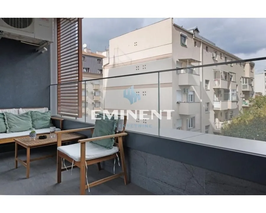 Furnished terrace with seating furniture and a glass railing.