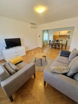 Living room with a sofa set, television, and a view of the dining area and kitchen in the background. - image 4